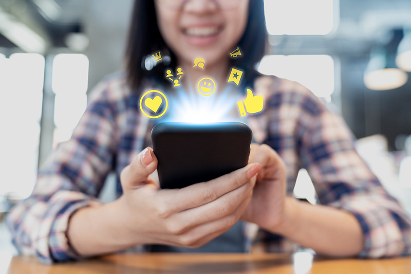Content creation company photograph of a woman using smartphone for social engagement community management conversational marketing customer service