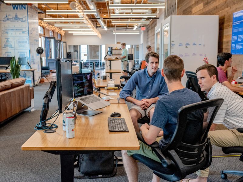 Men at office desk discussing social media strategy