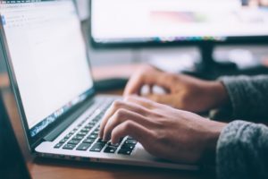 Photo of someone typing on a computer to show writing abilities and services of a content marketing agency