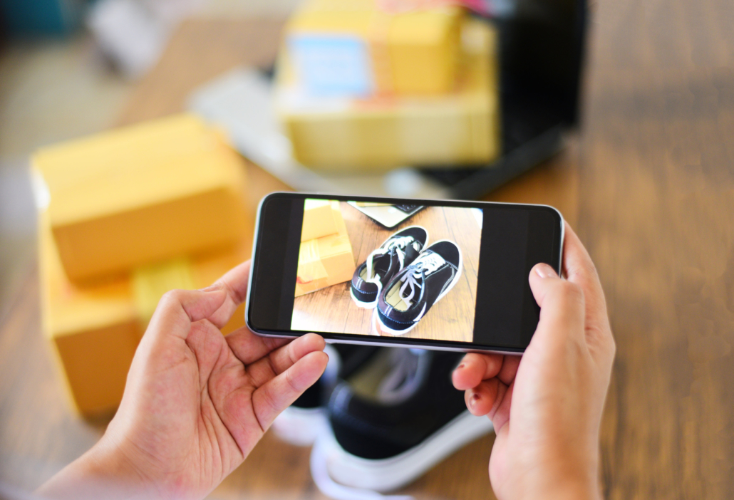 Influencer using an iphone to take a photo of shoes for an Instagram trend to post for their followers.