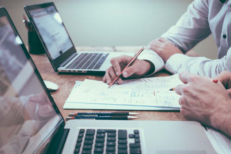 planning social media posts at desk with laptops