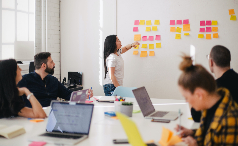 A social media community management team presents ideas through sticky notes
